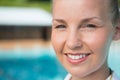 Smiling female coach standing near poolside