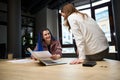 Smiling female colleagues whispering and conferring privately