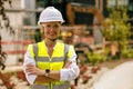 Smiling female construction worker in protective helmet standing against on construction background Royalty Free Stock Photo