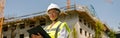 Smiling female construction worker in protective helmet standing against on construction background Royalty Free Stock Photo