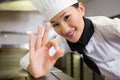 Smiling female cook gesturing okay sign in kitchen Royalty Free Stock Photo