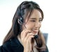 Smiling female customer support operator with headset working in office, Asian young woman working in call centre Royalty Free Stock Photo