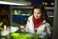 Smiling female customer watching fish in aquarium tank Royalty Free Stock Photo