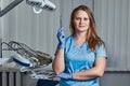 Smiling female dentist holding dental mirror while standing in her dentist office. Royalty Free Stock Photo