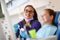 Dentist with girl in dental chair looking at her dental x-ray footage Royalty Free Stock Photo