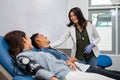 smiling female doctor advising a blood transfusion patient lying