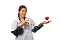 Smiling female doctor cardiologist holding and pointing at red heart. Cardiology, medicine, donation and healthcare