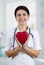 Smiling Female doctor holding red heart and stethascope Royalty Free Stock Photo