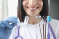 Smiling female doctor holds transparent plastic mouth guard and stomatological instruments in her hand Royalty Free Stock Photo