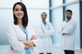 Smiling female doctor in lab coat with arms crossed against Royalty Free Stock Photo