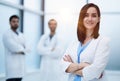 Smiling female doctor in lab coat with arms crossed against Royalty Free Stock Photo