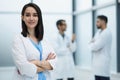 Smiling female doctor in lab coat with arms crossed against Royalty Free Stock Photo