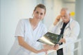 Smiling female doctor looking at x-ray in hospital corridor Royalty Free Stock Photo