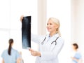 Smiling female doctor looking at x-ray image Royalty Free Stock Photo