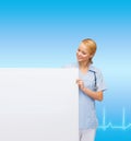 Smiling female doctor or nurse with blank board Royalty Free Stock Photo