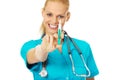 Smiling female doctor or nurse with stethoscope holding syringe Royalty Free Stock Photo