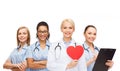 Smiling female doctor and nurses with red heart