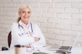 Smiling female doctor portrait while sitting at desk at the doctor`s office Royalty Free Stock Photo