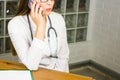 Smiling Female Doctor Relaxing at her Office While Calling to Someone Using a Mobile Phone close-up. Royalty Free Stock Photo