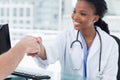 Smiling female doctor shaking a hand Royalty Free Stock Photo