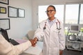 Smiling female doctor shaking hand of female patient Royalty Free Stock Photo