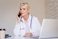 Smiling female doctor sitting at desk and working in the doctor`s office Royalty Free Stock Photo