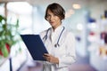 Smiling female doctor standing at the clinic\'s foyer and holding clipboard in her hand Royalty Free Stock Photo