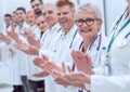 smiling female doctor standing in front of her applauding colleagues. Royalty Free Stock Photo