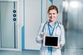 smiling female doctor with stethoscope over neck showing digital tablet with blank screen Royalty Free Stock Photo