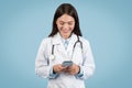 Smiling female doctor texting on phone Royalty Free Stock Photo