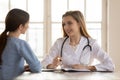 Smiling female doctor therapist consulting patient at medical appointment