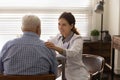 Smiling female doctor touch elderly male shoulder reassure give hope Royalty Free Stock Photo