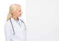 Smiling female doctor with white blank board Royalty Free Stock Photo