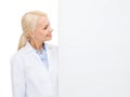 Smiling female doctor with white blank board Royalty Free Stock Photo