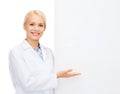 Smiling female doctor with white blank board Royalty Free Stock Photo