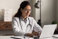 Smiling female doctor work on computer in hospital