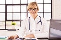 Smiling female doctor working at desk in doctor`s office in the hospital Royalty Free Stock Photo