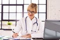 Smiling female doctor working at desk in doctor`s office in the hospital Royalty Free Stock Photo