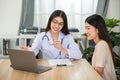 Smiling female doctor working on her laptop in consultation at the clinic office Medical worker writing a prescription on a table Royalty Free Stock Photo