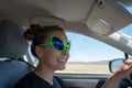 Smiling female driving a car wears alien bug eye sunglasses while on Nevada`s Extraterrestrial Highway Royalty Free Stock Photo