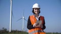 Smiling female engineer standing against wind farm Royalty Free Stock Photo