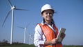 Smiling female engineer standing against wind farm Royalty Free Stock Photo