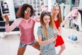 Smiling female friends having fun, making video or selfie while doing a funny dance in fashion showroom Royalty Free Stock Photo