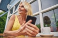 Smiling female with a gadget looking away