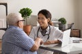 Smiling doctor handshake old male patient in hospital