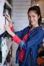 Smiling female hair dresser selecting shampoo from shelf at a salon Royalty Free Stock Photo