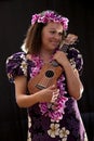 Smiling female Hawaiian girl dancing and singing with musical instruments like the ukulele Royalty Free Stock Photo