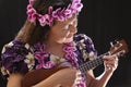 Smiling female Hawaiian girl dancing and singing with musical instruments like the ukulele Royalty Free Stock Photo