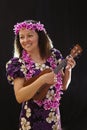 Smiling female Hawaiian girl dancing and singing with musical instruments like the ukulele Royalty Free Stock Photo