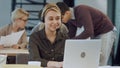 Smiling female helpline operator with headphones at her desk in the office Royalty Free Stock Photo